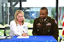 Ms. Gee signs the Buffalo Rock Company ceremonial MOA, LTC Johnson awaits his turn to sign. 