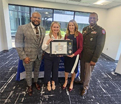 Victor Fleming, Malanie Gee, Jennifer Zelko, and LTC Johnson pose with the ceremonial plaque. 