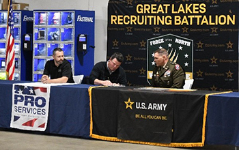 Mr. WIlmonth signs, as LTC Heffner and Mr. Haddock look on.