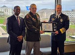 MG Manke presents plaque to Chief Henry as Mayor Carter looks on.