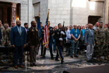 The audience stands for posting of the Colors. 