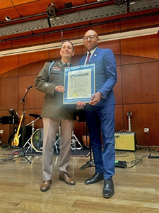 The Hon. Donovan Richards presents LTC Rhodes with the proclamation 