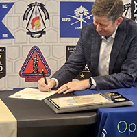 Mr. Henry signs the MOA for partnership
